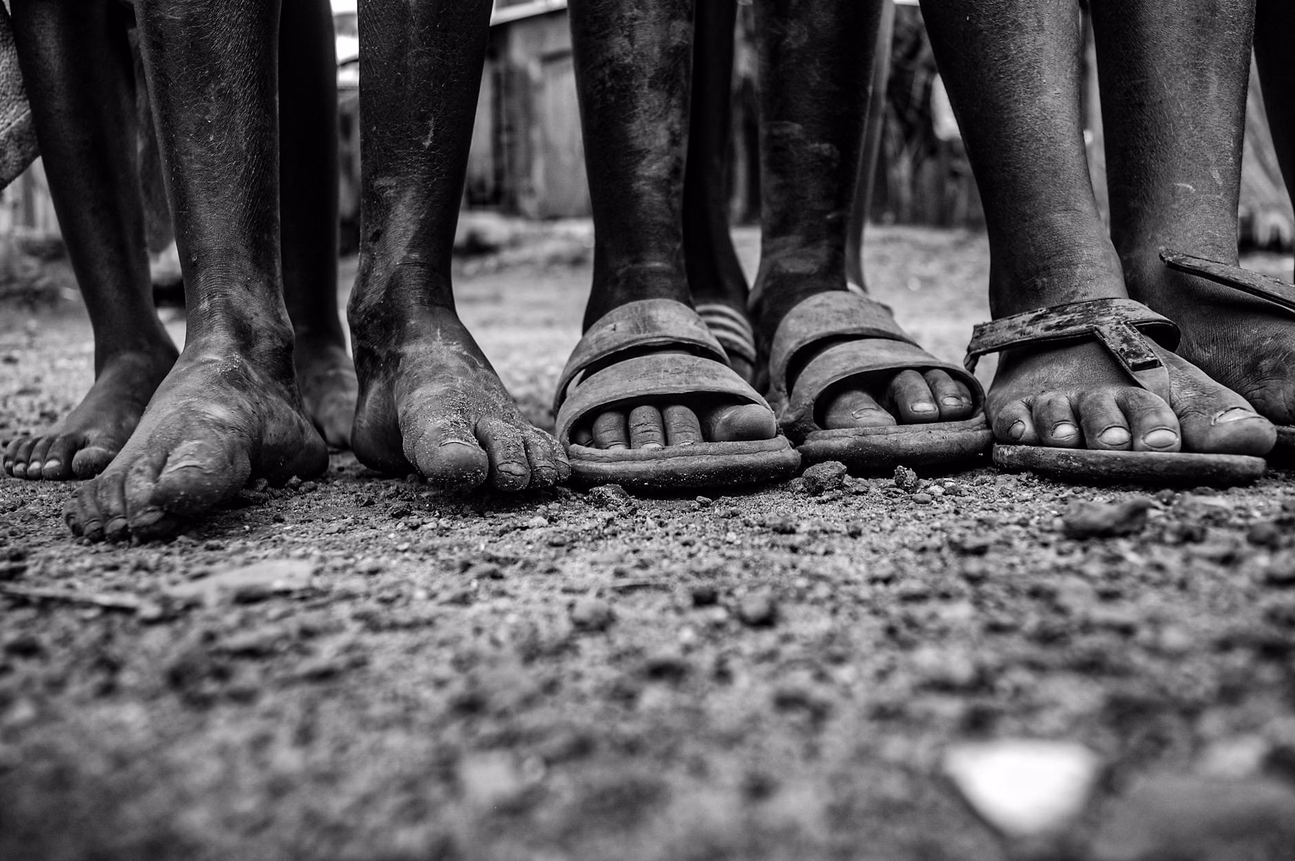 black and white photo of bare feet and dust